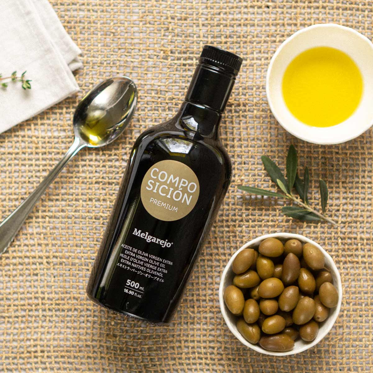 Olivenölflasche Melgarejo, Oliven, Löffel, Schale, Tuch, Zweig.