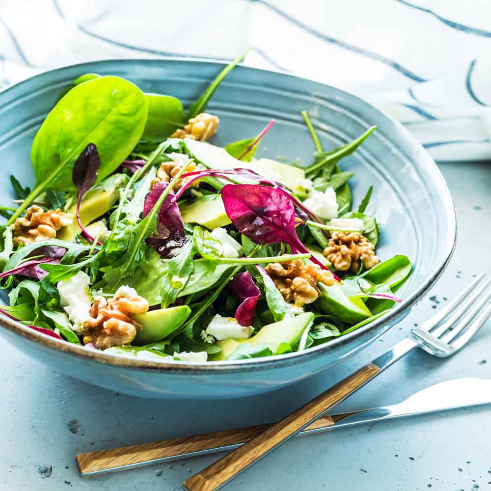 Salat mit Walnüssen, Blättern, Avocado und mildem Olivenöl.