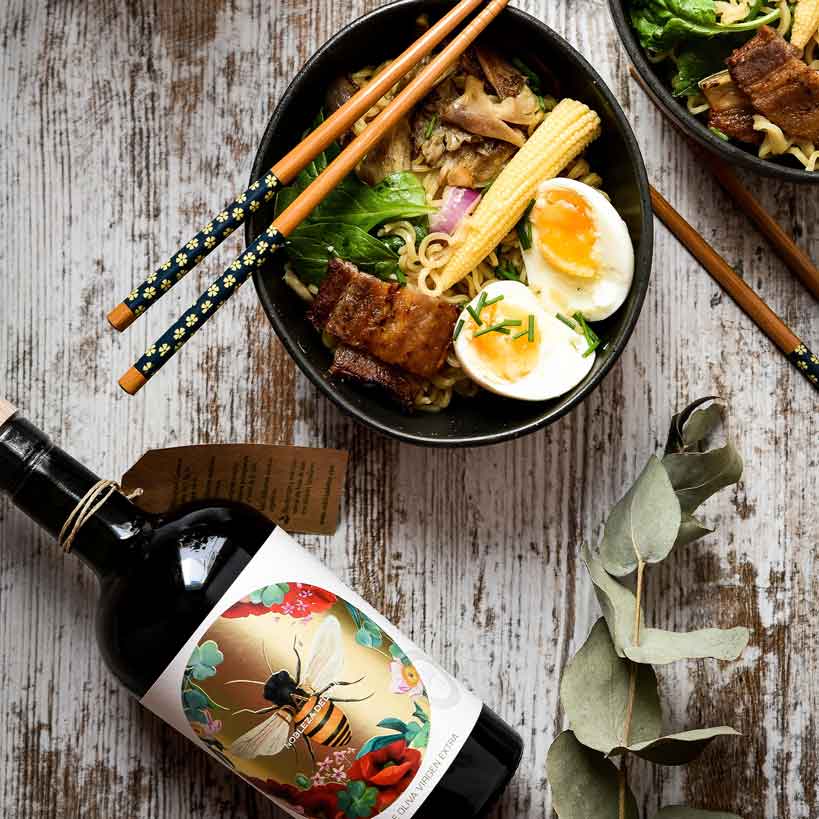 Flasche Olivenöl, Schüssel mit Essen, Essstäbchen, Eukalyptuszweig.