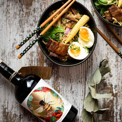 Flasche Olivenöl, Schüssel mit Essen, Essstäbchen, Eukalyptuszweig.