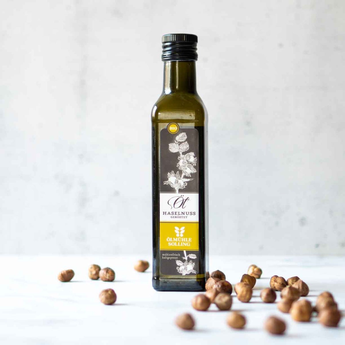 Flasche Haselnussöl von Ölmühle Solling mit Haselnüssen.