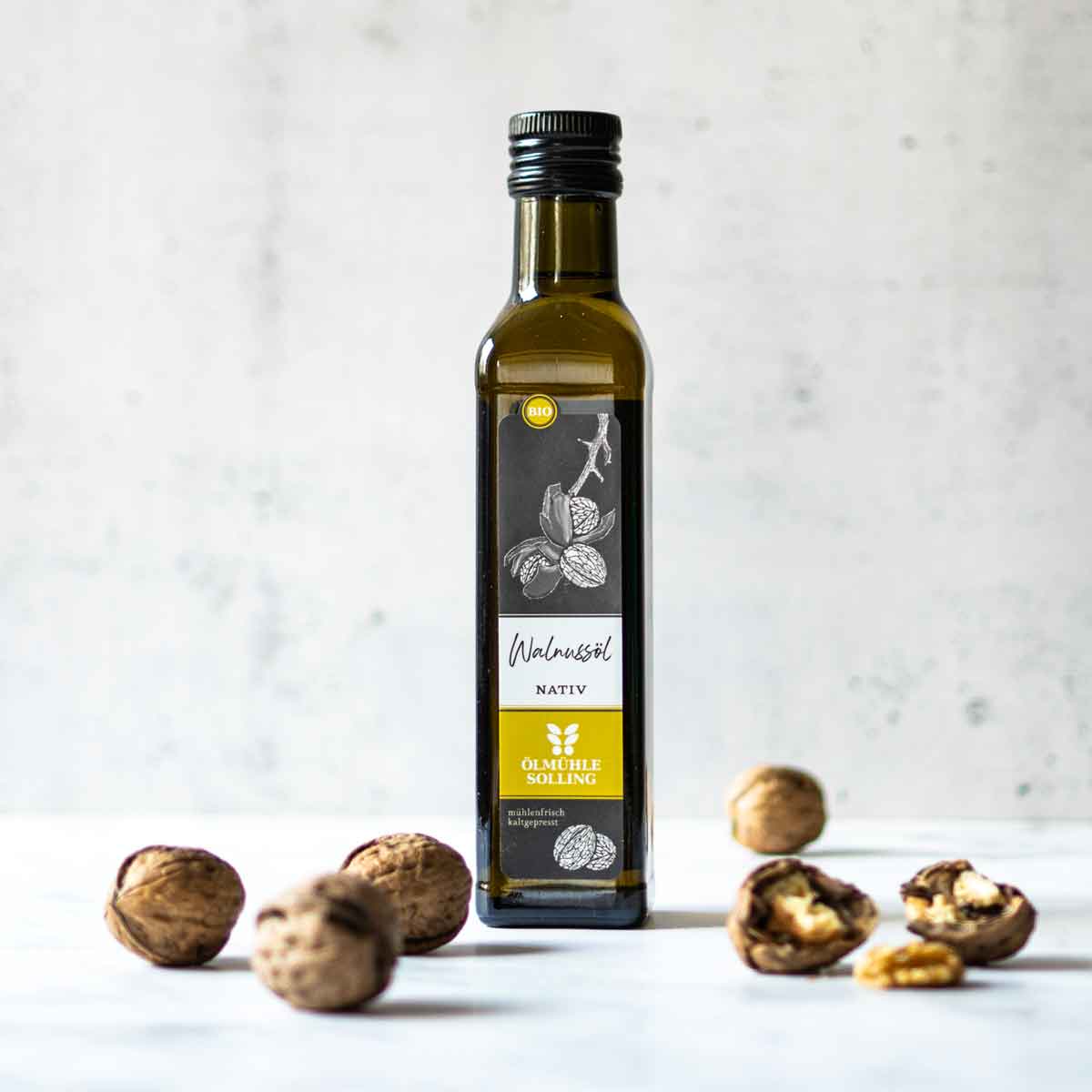 Ölmühle Solling Walnussöl Flasche mit Walnüssen auf Tisch.