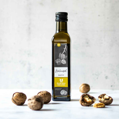 Ölmühle Solling Walnussöl Flasche mit Walnüssen auf Tisch.