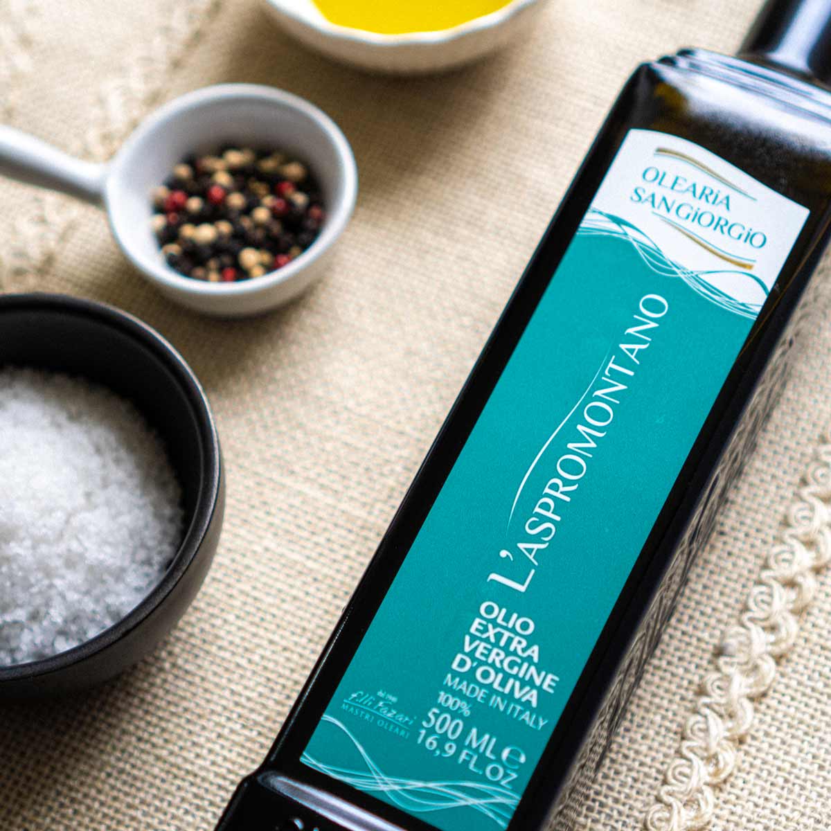 Olearia San Giorgio Olivenölflasche mit Etikett und Gewürzen.