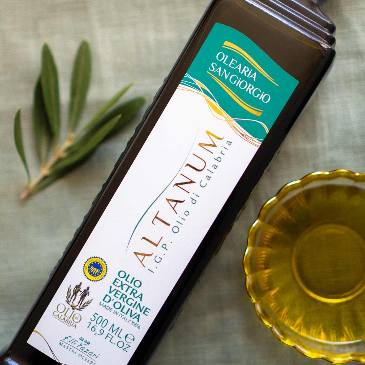 Olivenölflasche Olearia San Giorgio Altanum mit Olivenzweig.