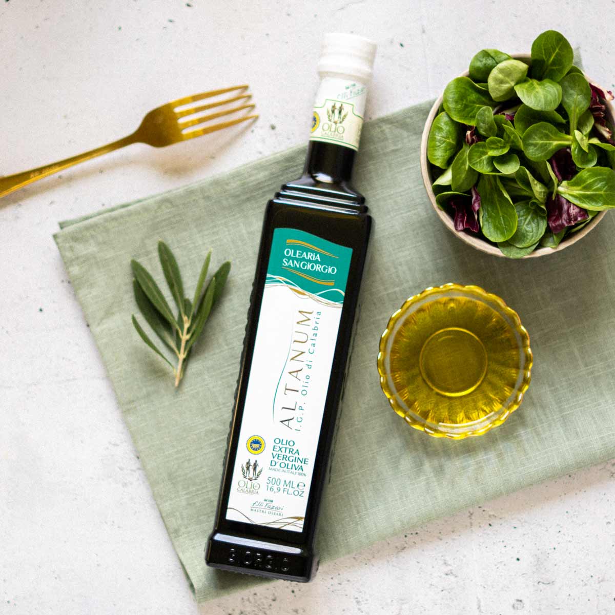 Olivenölflasche, Salat, Olivenzweig, Gabel, Schale mit Öl.