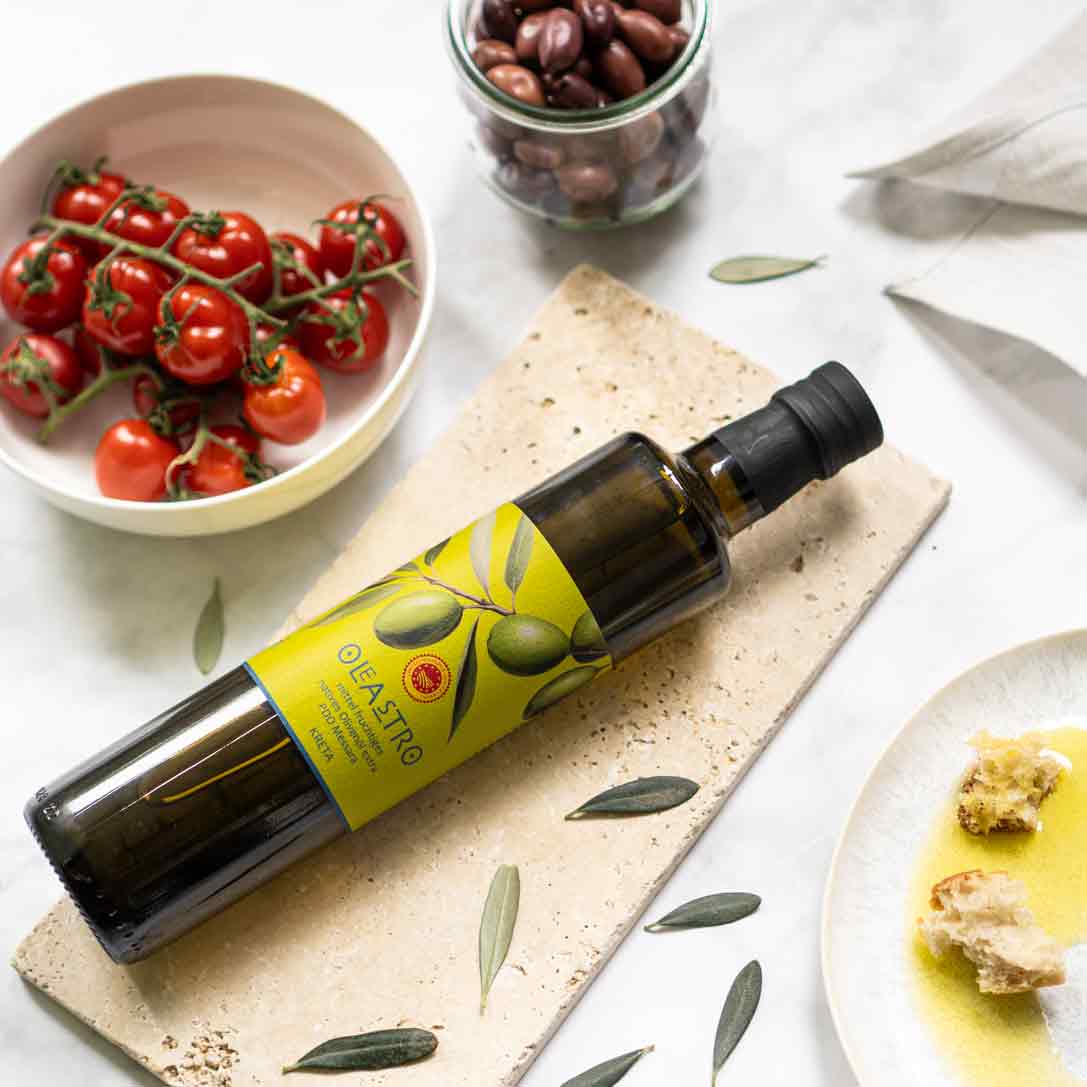 Oleastro Olivenölflasche, Tomaten, Oliven, Brot auf Tisch.