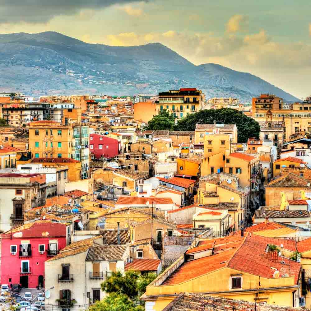 Stadtansicht mit Bergen im Hintergrund.