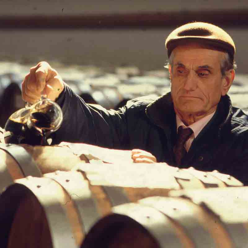 Mann prüft Essig in Weinkellerei.