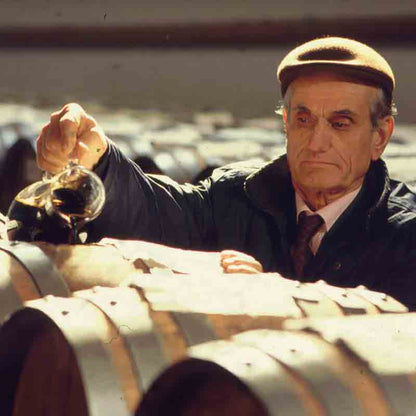 Mann prüft Essig in Weinkellerei.