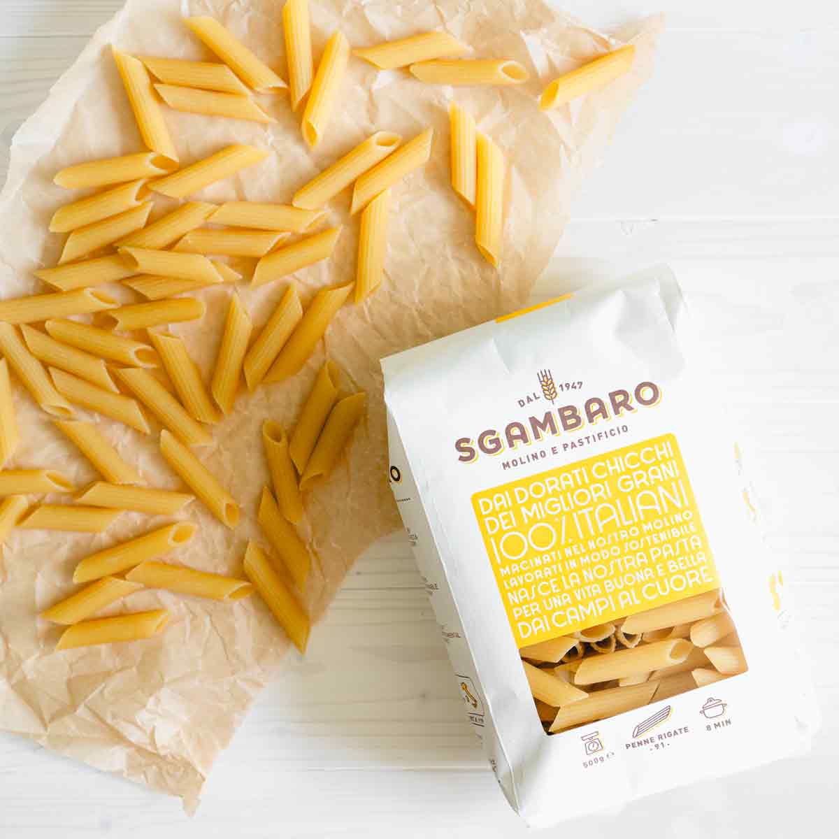 Penne-Nudeln und Sgambaro-Verpackung auf Papierunterlage.