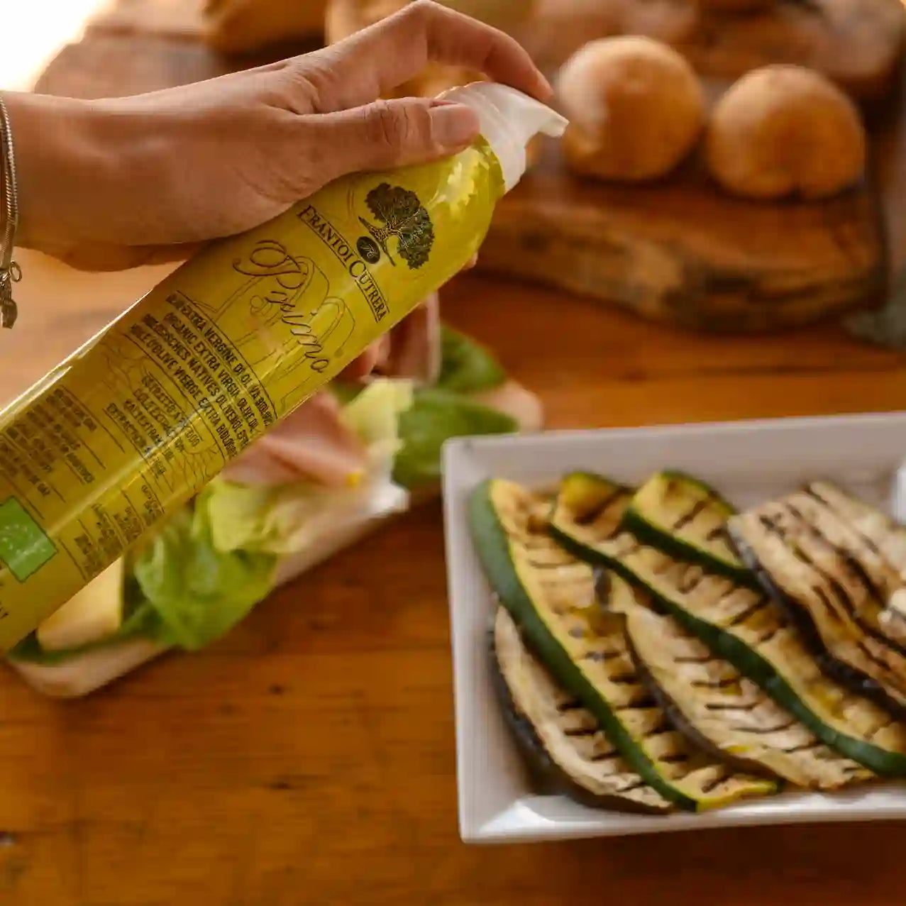 Öl wird mit der Sprühflasche auf Antipasti gesprüht