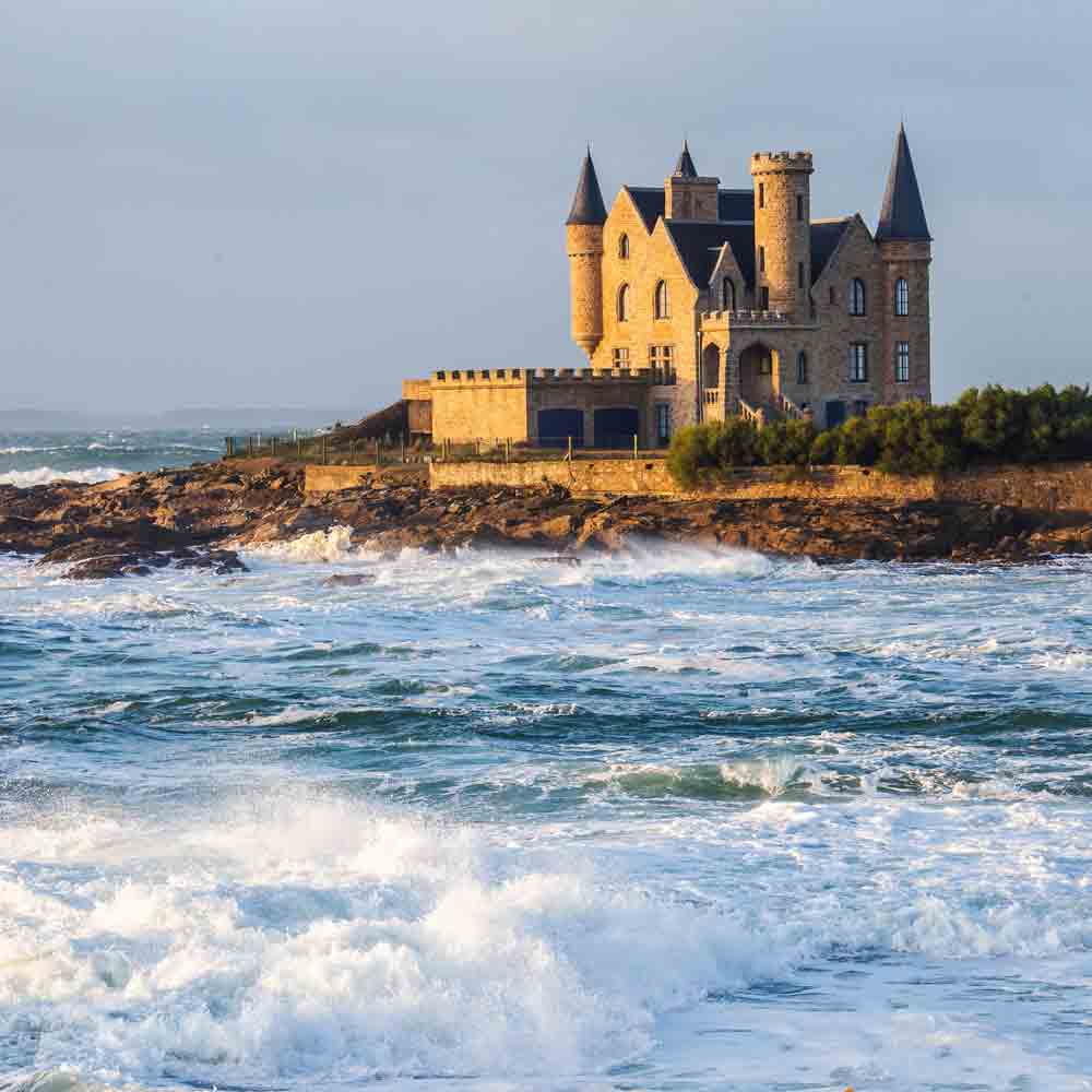 Schloss am Meer bei Wellengang.