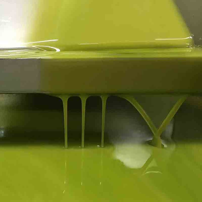 Fließendes Olivenöl in Nahaufnahme, grünliche Farbe, glänzend.