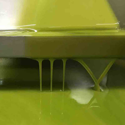 Fließendes Olivenöl in Nahaufnahme, grünliche Farbe, glänzend.