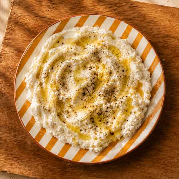 Zubereitete Ricottacreme mit Honig, Zitrone, Olivenöl, Salz und Pfeffer