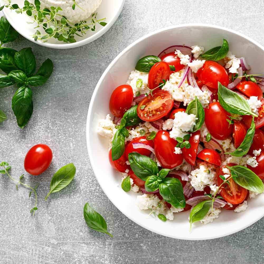 Tomatensalat mit Basilikum, Zwiebeln, Feta und Olivenöl.