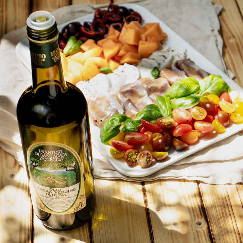 Olivenölflasche Frantoio Sant'Agata d'Oneglia neben Antipasti.