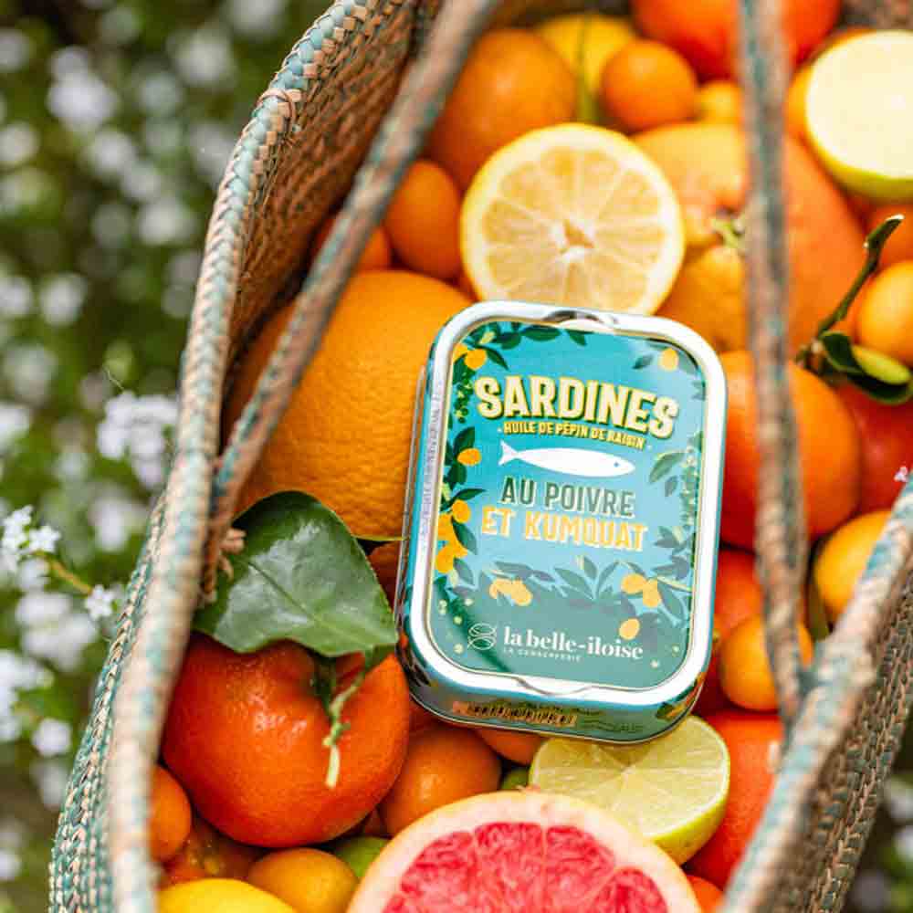 Sardinen-Dose mit Zitrusfrüchten in einem Korb.