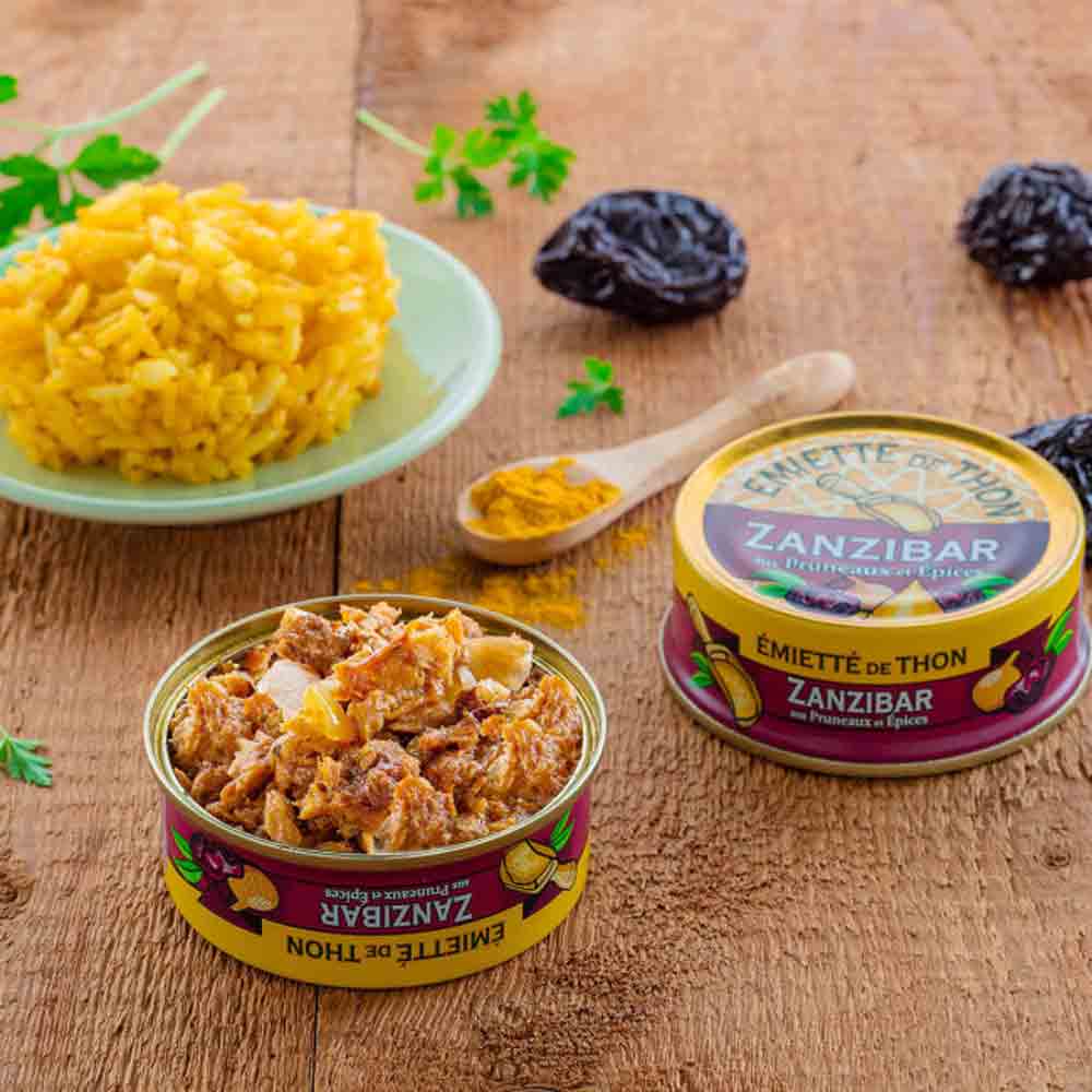 Feinkostprodukte auf Holztisch mit Reis und Gewürzen.