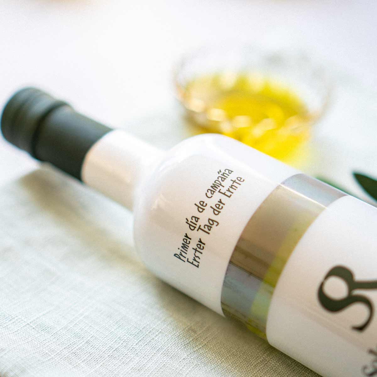 Flasche Soler Romero Olivenöl auf Tisch mit Schale.