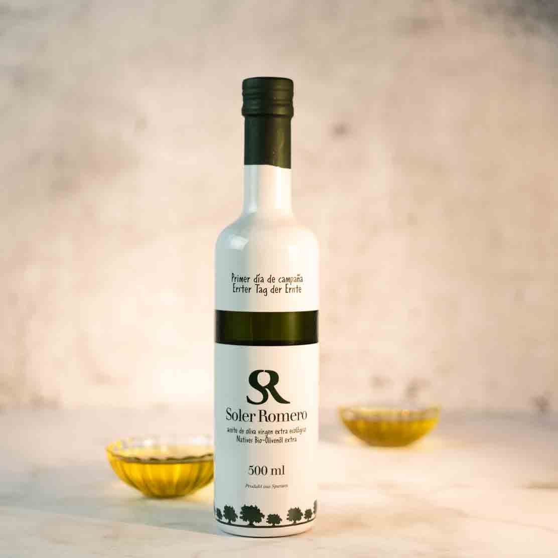 Flasche Soler Romero Olivenöl mit Schalen im Hintergrund.
