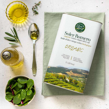 Soler Romero Olivenöl Kanister auf Tisch mit Zubehör.