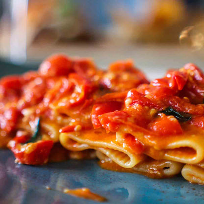 Pasta mit Tomatensauce auf einem Teller angerichtet.