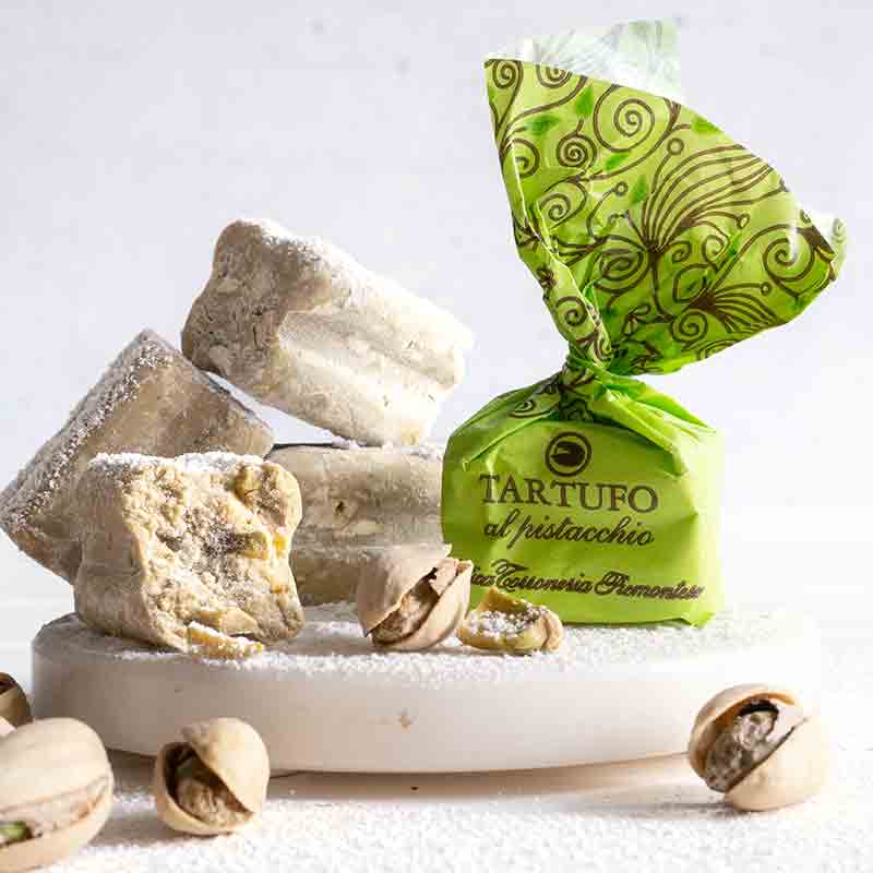 Pistazien-Trüffel und Pistazien auf weißem Hintergrund.