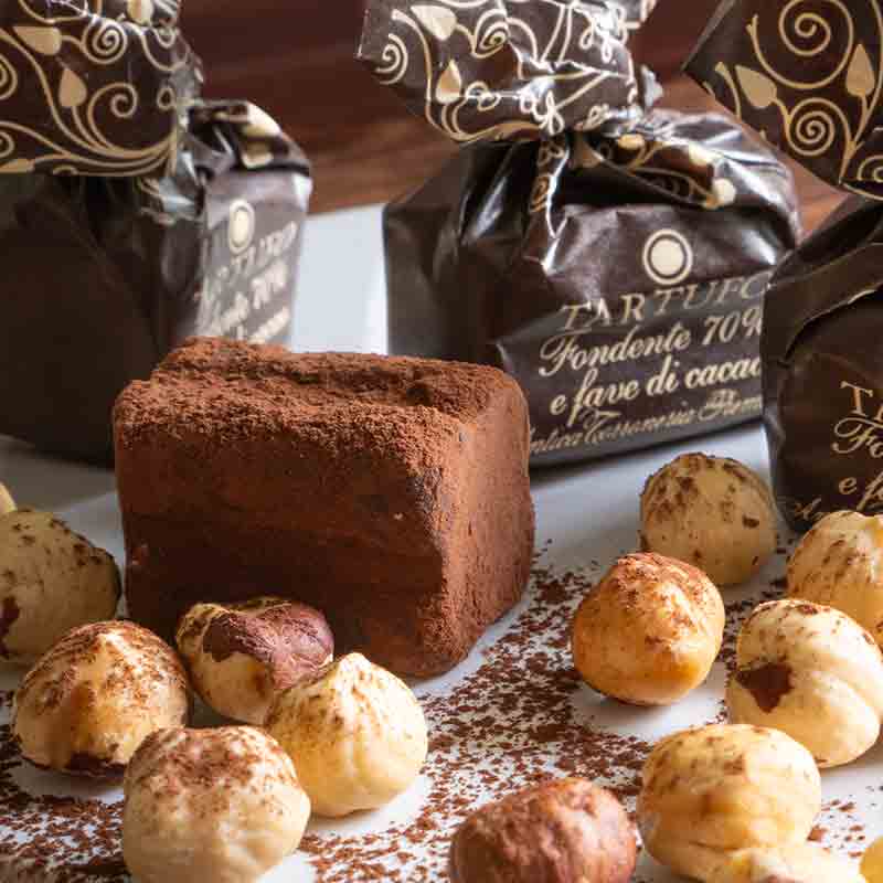 Tartufo Fondente Cacao Pralinen und Nüsse auf Teller.