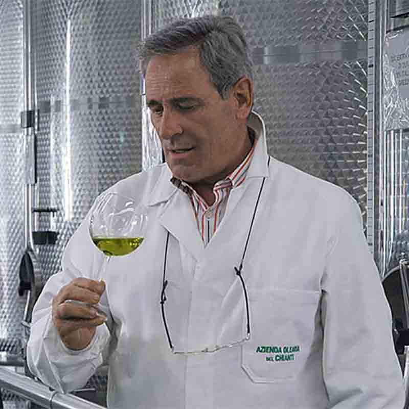 Mann verkostet Olivenöl im Glas.