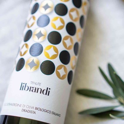 Flasche Tenute Librandi Olivenöl mit Olivenzweig daneben.