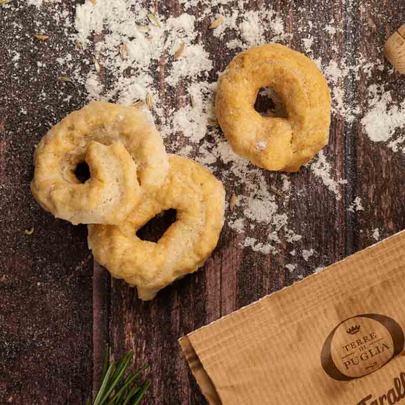 Feinkostgebäck auf Holzuntergrund, Marke Terre di Puglia sichtbar.