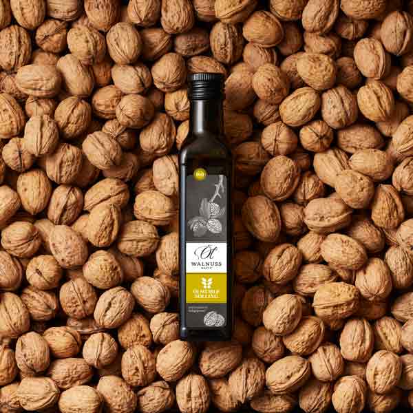 Walnussölflasche auf Walnüssen liegend, Marke Ölmühle Solling.