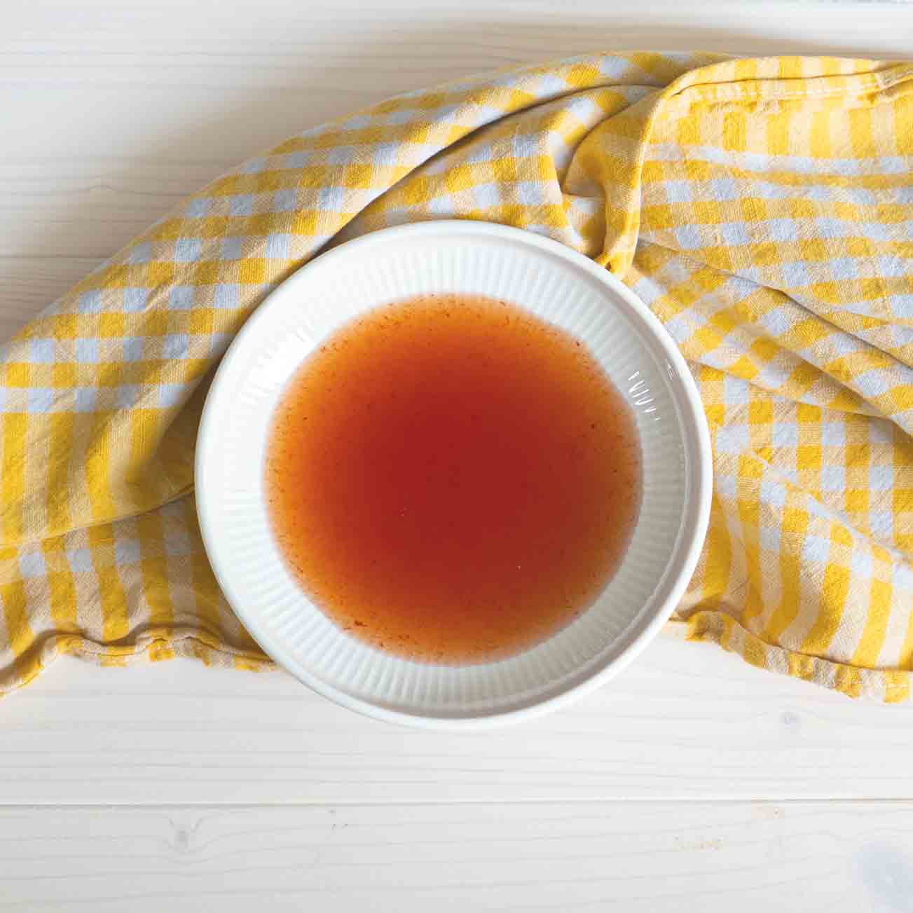 Roter Balsamessig in einer weißen Schale. Süßer weißer Balsamico mit intensivem Aroma.