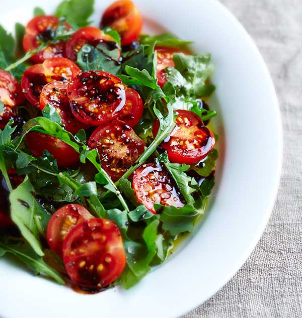 Tomaten-Rucola-Salat mit Olivenöl und Balsamico-Essig.