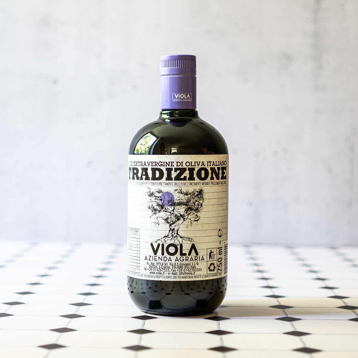 Flasche Viola Tradizione Olivenöl auf gemustertem Untergrund.