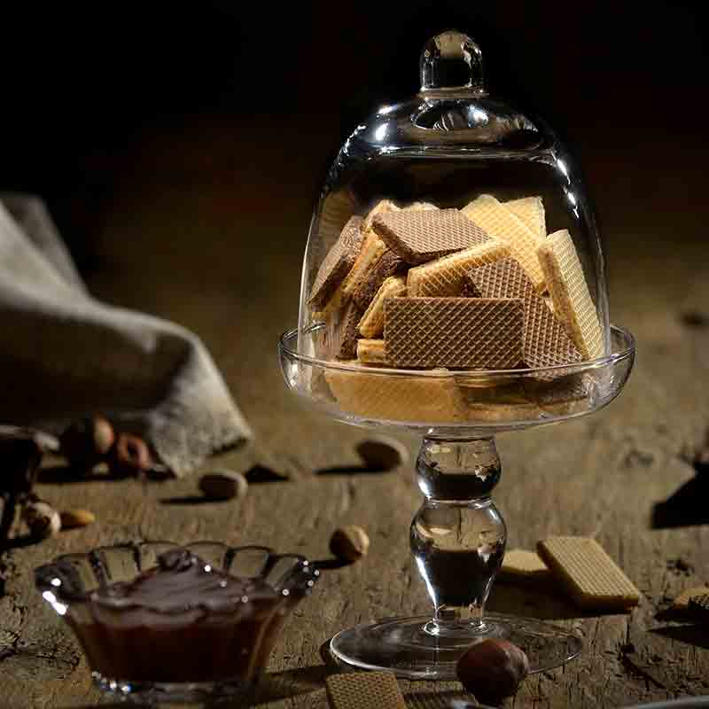 Waffeln in Glasgefäß auf Holztisch mit Nüssen.