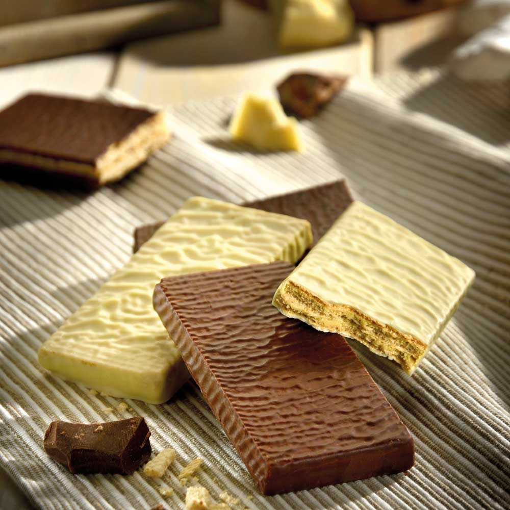 Verschiedene Waffeln mit Schokolade und Vanille auf Tisch.